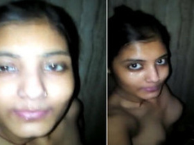 A young Indian woman films herself in a dimly lit bathroom for a steamy XXX video