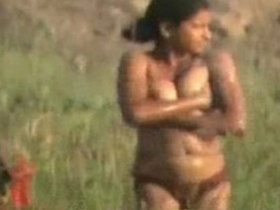 A young Indian girl bathes naked in the great outdoors